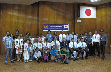 Group photo of former international students indoors.