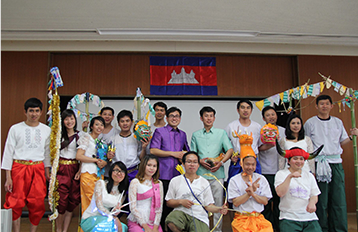 在室内拍摄的学生合照。墙上悬挂柬埔寨国旗。
