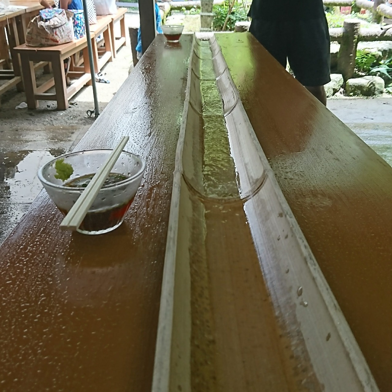 A splitted bamboo with water flowing through it. (Used when eating Nagashi-Somen where the somen will flow with the water in it.)