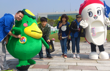 People interacting with someone dressed up as a mascot character.