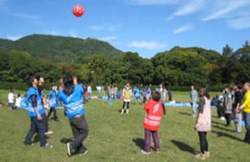 Students playing ball on a grass field.