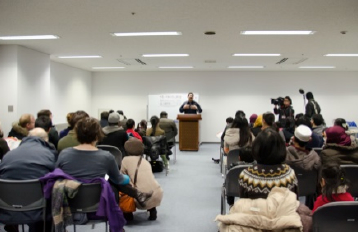 Participants listening attentively to a presenter in a meeting room.