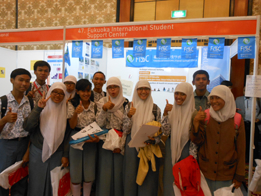 International students, both men and women, smiling and posing for the photo.