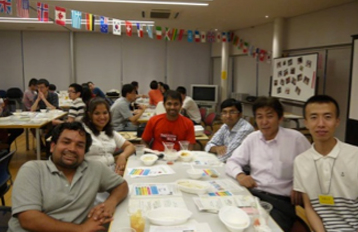 Former international students, separated into groups, are gathering around tables.