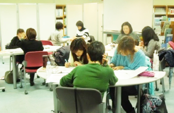 Students studying at the Fukuoka International Exchange Center. 2 to 3 students are studying at each table.