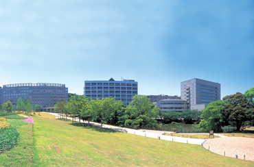 福岡工業大学の全景。手前に芝生、奥に複数の建物がある。