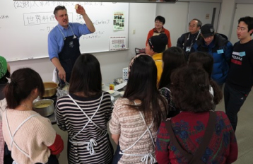 外国人講師が生徒たちに料理を教えている料理教室の様子