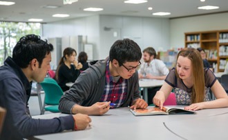 Suasana pelajar asing yang sedang belajar kelompok di perpustakaan